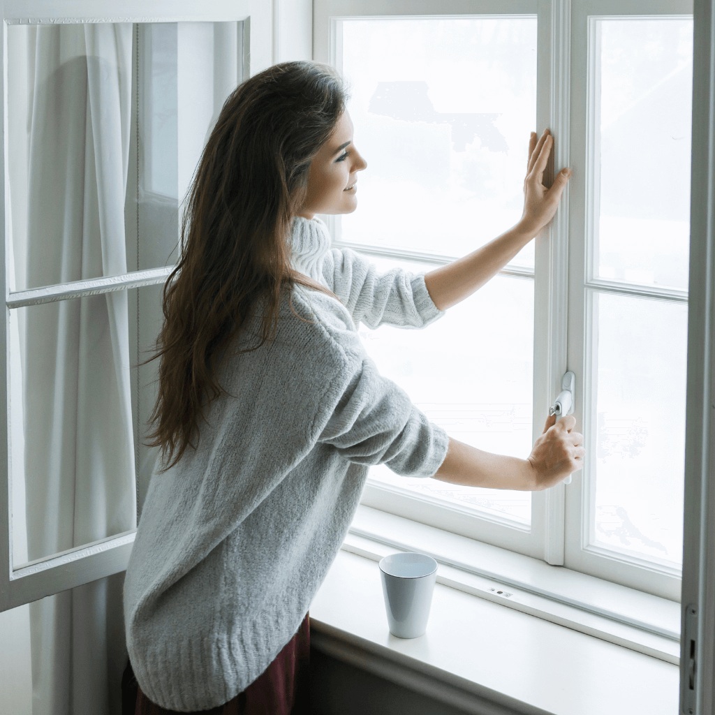 Femme ouvrant une fenêtre